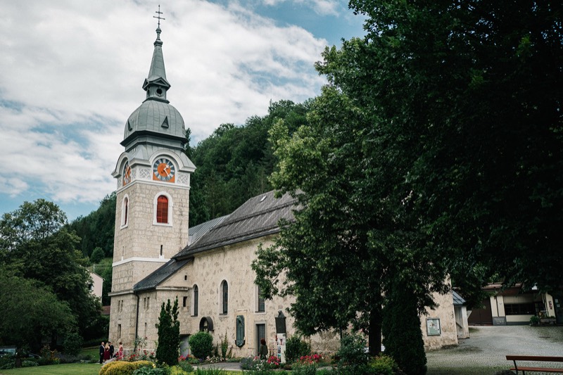 Dorfkirche mit Zwiebelturm unter Bäumen vor der Trauung