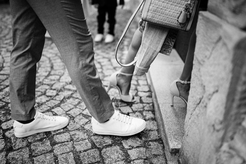 Weiße Sneaker auf dem Kopfsteinpflaster vor der Kirche