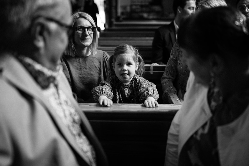 Gäste in den Kirchenbänken warten auf die Braut