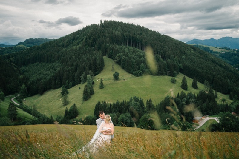 Brautpaar klein in der weiten Landschaft der Voralpen