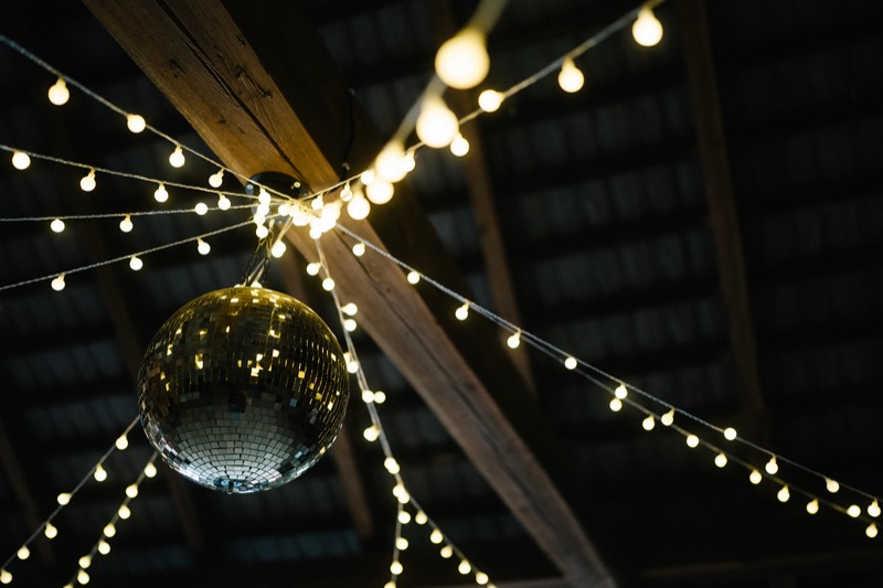 Lichterketten und Discokugel unter dem Stadeldach