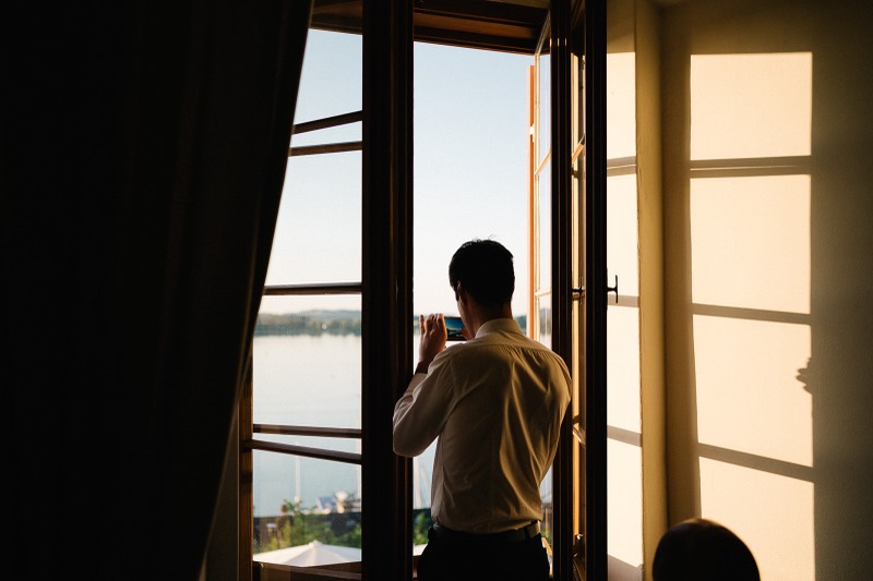 Brautpaar am Fenster mit Blick auf den See
