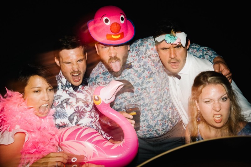 Gäste mit Flamingo-Schwimmring und Gummiente-Hut